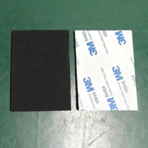 Black EPDM foam pad beside its adhesive liner